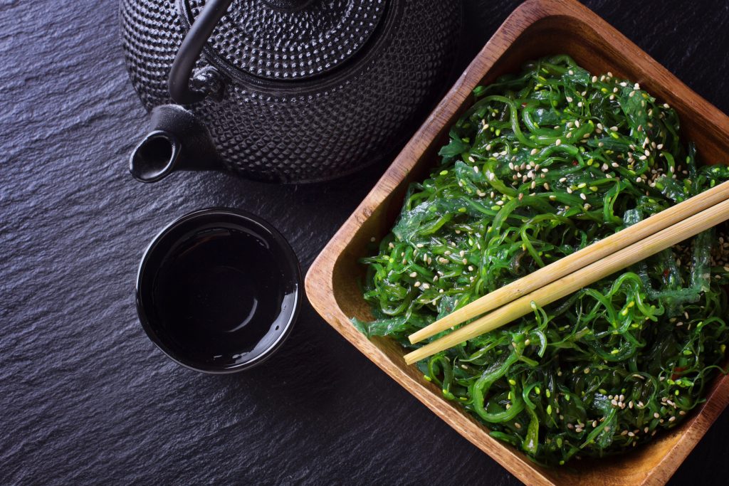 紫菜裙带菜沙拉,茶壶和杯子放在黑色石板上。